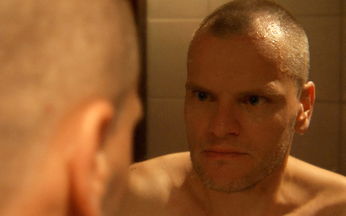 Thomas Schweiss, played by Stefan Kolosko, reflected in a mirror